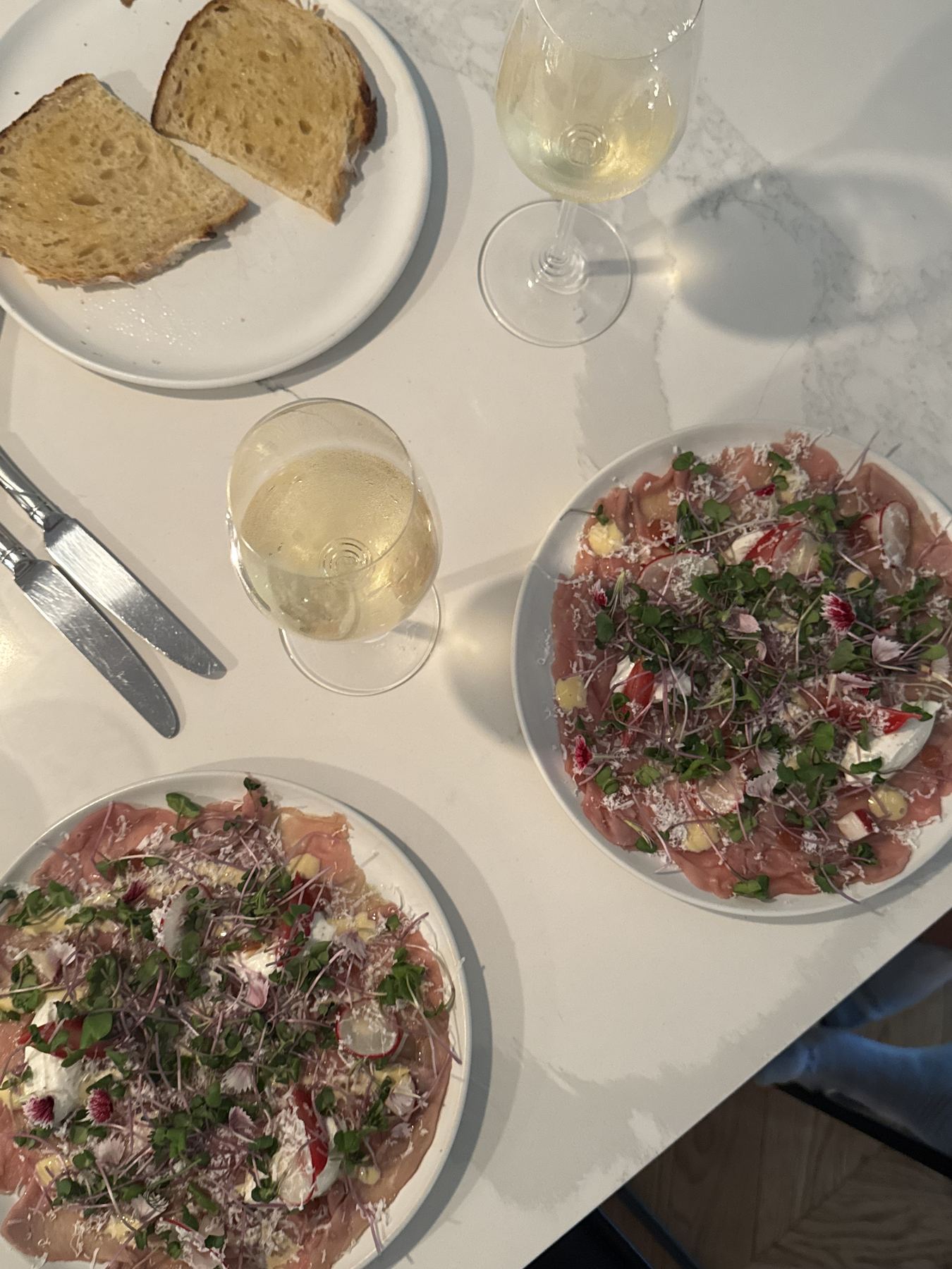 Table dressée, carpaccio et vin blanc